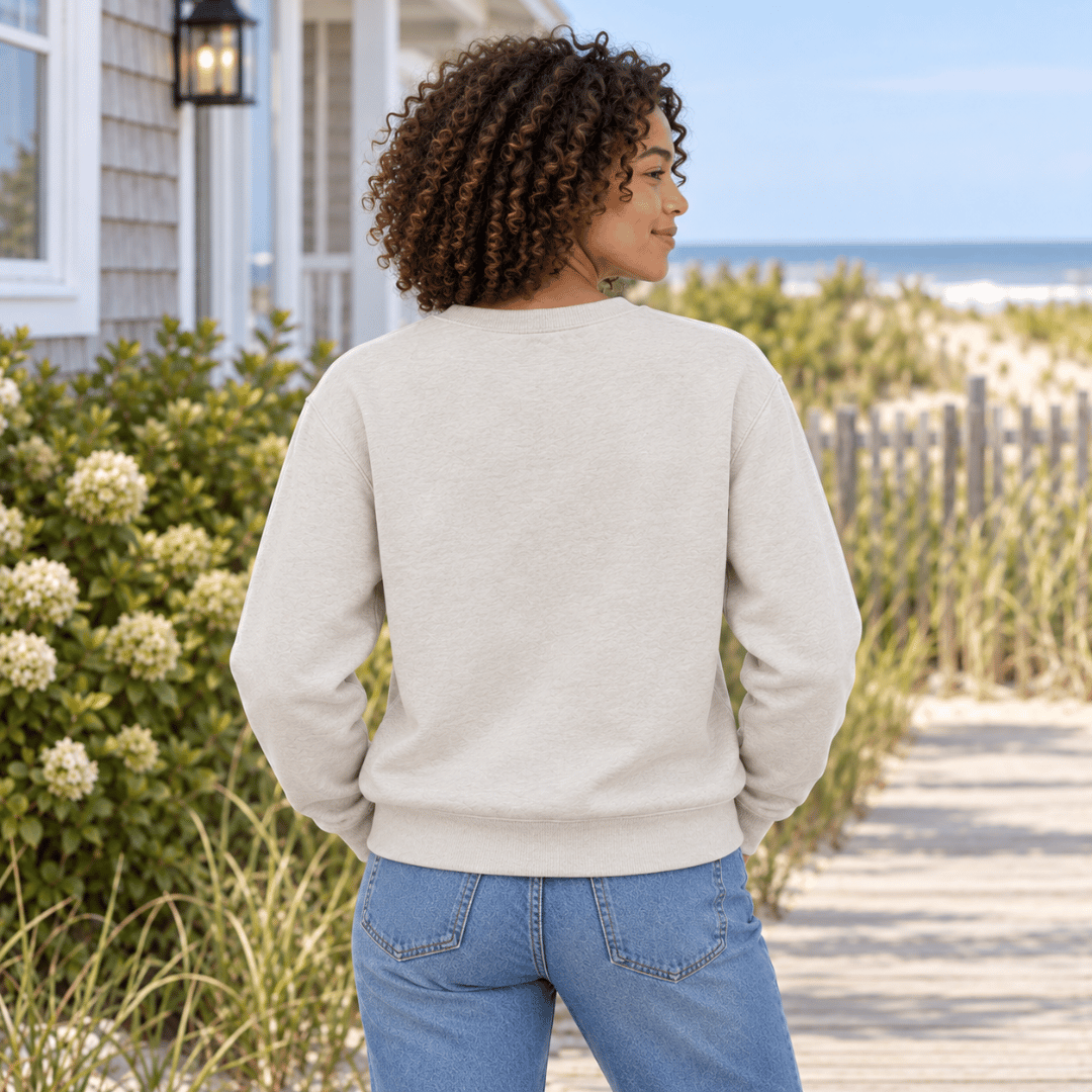 Back view of a woman wearing a plain Heather Dust crewneck sweatshirt near beach dunes