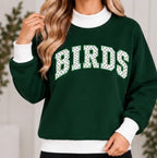 Woman wearing dark green BIRDS polka dot game day mock neck sweatshirt