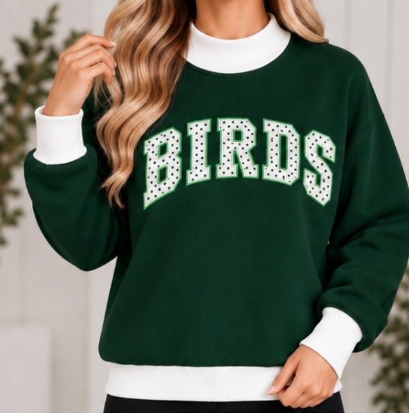 Woman wearing dark green BIRDS polka dot game day mock neck sweatshirt