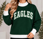 Woman wearing dark green EAGLES polka dot game day mock neck sweatshirt