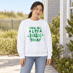 Woman wearing a white crewneck with green “We’re All a Little Irish Today” lettering and shamrocks