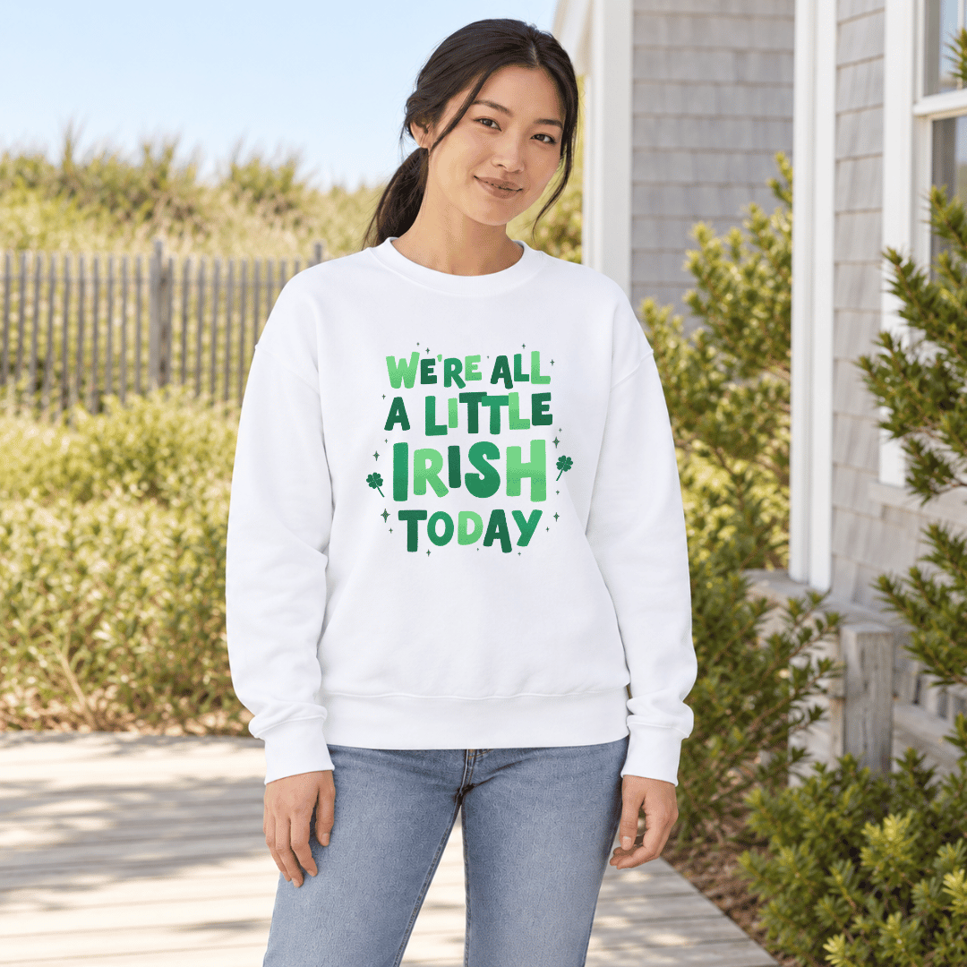 Woman wearing a white crewneck with green “We’re All a Little Irish Today” lettering and shamrocks