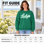 A woman wearing a green crewneck sweatshirt with a white 'Lucky' graphic stands on a porch, with a fit guide and size chart overlay. The graphic includes text reading 'FIT GUIDE' and 'RELAXED UNISEX FIT' with size tables at the bottom.