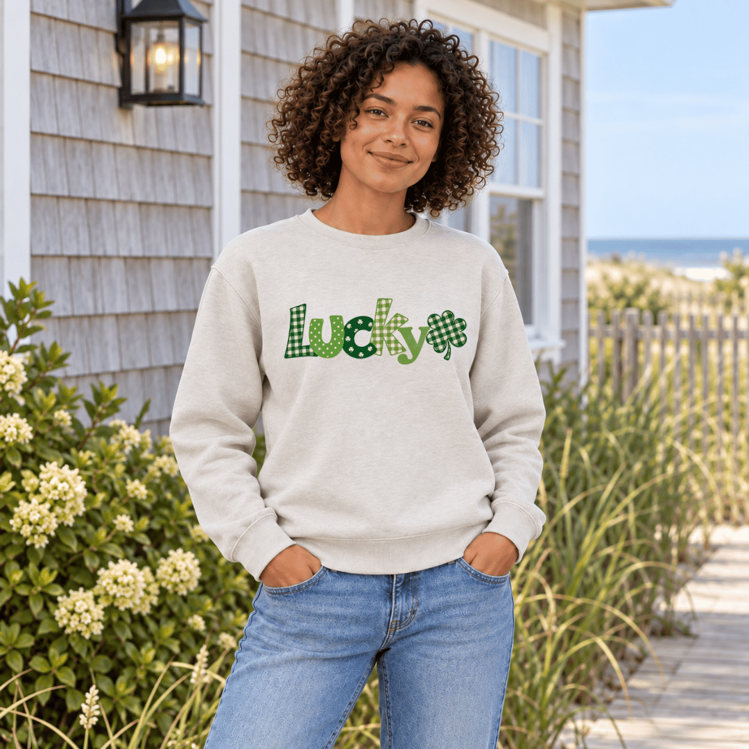 Woman wearing a Heather Dust crewneck sweatshirt with a green patterned Lucky design and shamrock