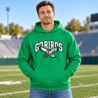 Man in jeans standing on a football field, wearing a Kelly green pullover hoodie with white varsity GO BIRDS lettering and an eagle carrying a football on the chest