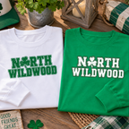 Kelly green and white North Wildwood Irish Weekend long sleeve graphic shirts folded in festive Irish themed display