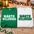 Folded Kelly Green and white crewneck sweatshirts showing their contrasting NORTH WILDWOOD designs