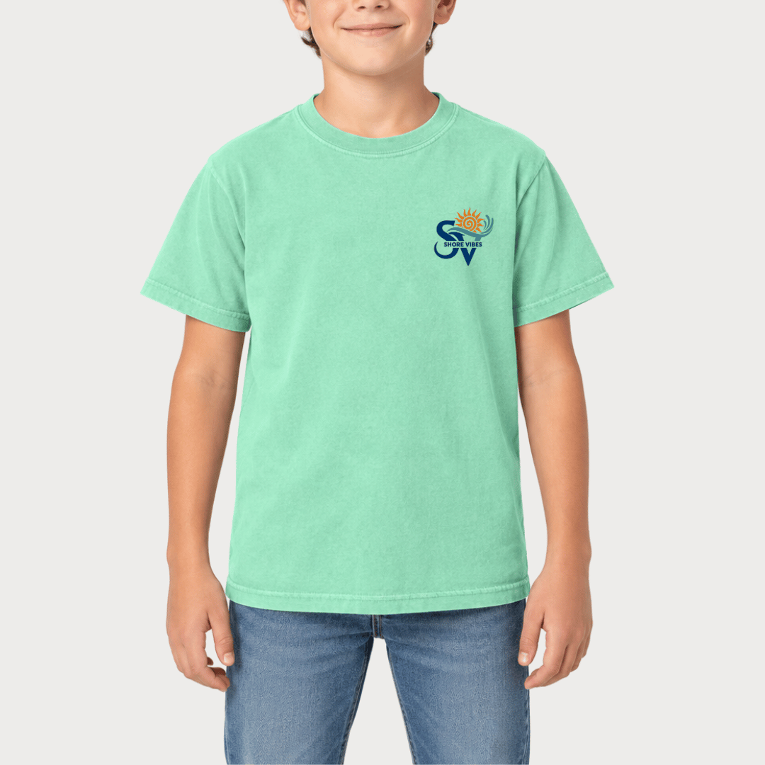 Boy wearing an Island Reef green Shore Vibes t-shirt with the front logo, studio photo