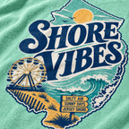 A close-up of a island reef t-shirt featuring a distressed graphic print of the state of New Jersey. The graphic reads 'SHORE VIBES' in large navy blue letters, with a yellow sun, blue ocean waves, a Ferris wheel, and a sandy beach.