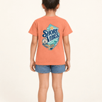 Back view of a girl in a Melon orange Shore Vibes t-shirt showing the full New Jersey coastal graphic, studio photo