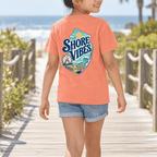 Girl in a Melon orange Shore Vibes t-shirt on a boardwalk path to the beach