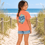 Back view of a girl in a Melon orange Shore Vibes t-shirt walking a boardwalk path toward the beach