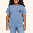 Girl wearing a Washed Denim blue Shore Vibes t-shirt with the front logo, studio photo