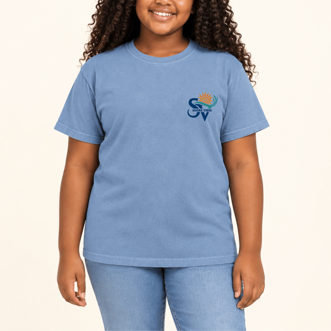 Girl wearing a Washed Denim blue Shore Vibes t-shirt with the front logo, studio photo