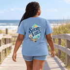 Back view of a girl in a Washed Denim blue Shore Vibes t-shirt walking away on a boardwalk near the beach