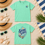 Island Reef green Shore Vibes t-shirt flat lay showing the front logo and full back graphic on a beach themed background