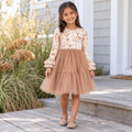 Girl wearing an off-white woodland animal print dress with ruffled long sleeves and a tan tiered tulle skirt