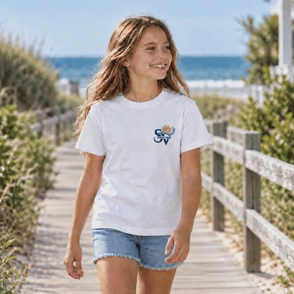 Girl wearing a white Shore Vibes t-shirt with the front logo, walking a boardwalk path near dune grass