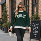 Woman wearing PHILLY game day mock neck sweatshirt in dark green and white